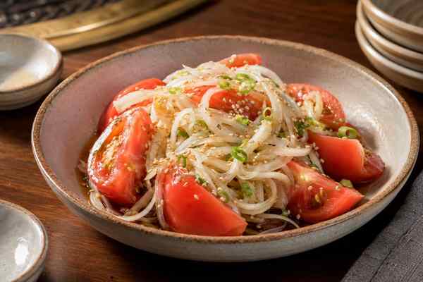 Finished Tomato-Onion Sesame Salad presented in a warm Korean dining setting.