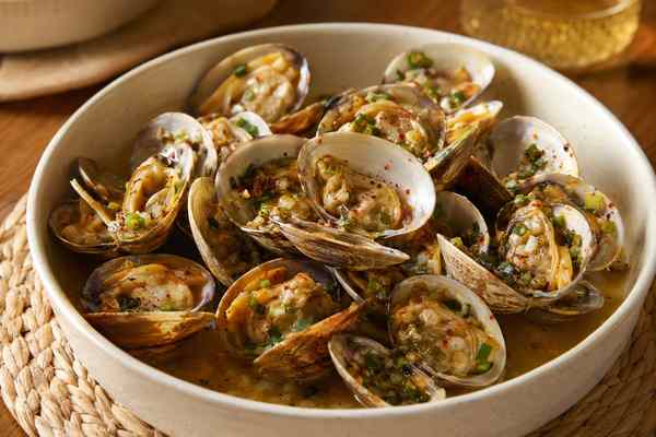 Finished Jogae Gui Grilled Clams presented in a warm Korean dining setting.