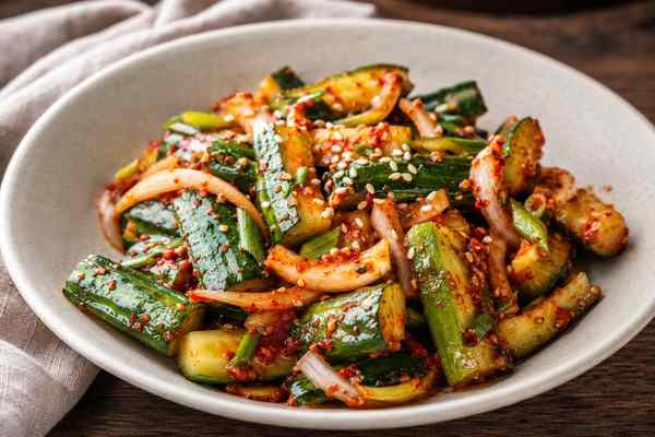 Finished Oi Muchim Spicy Cucumber Banchan presented in a warm Korean dining setting.