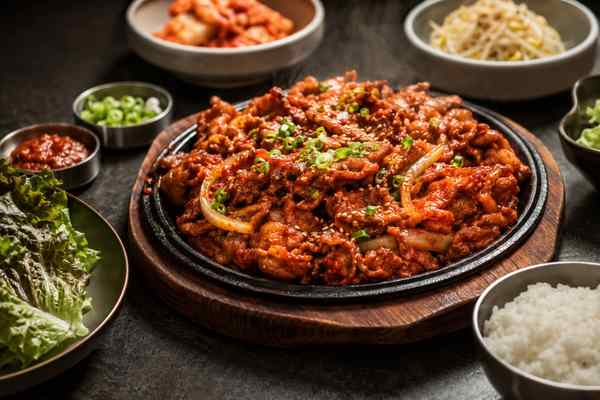 Finished Spicy Dwaeji Bulgogi presented in a warm Korean dining setting.