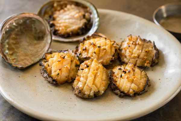 Finished Jeonbok Gui Grilled Abalone presented in a warm Korean dining setting.