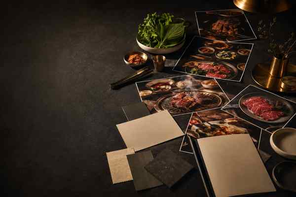 Borderless Korean barbecue photographs and unmarked material swatches arranged on a charcoal studio table.